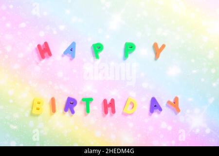 Fotografia di alcune lettere magnetiche con il testo inglese di Happy Birthday su sfondo di cartone colorato.la fotografia è scattata in forma orizzontale Foto Stock