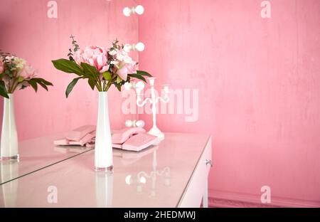 vaso su un tavolo in un interno rosa. spazio copia. Foto Stock
