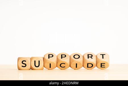 Concetto di supporto suicida. Flipping blocchi di legno con parole sul tavolo. Spazio di copia Foto Stock