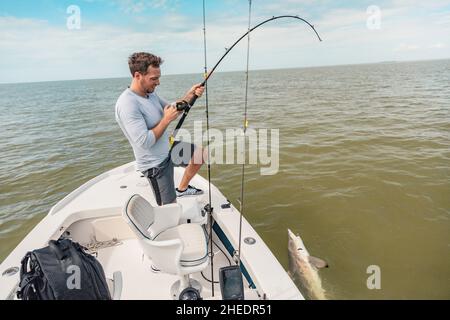 Pesca uomo sport pesca squalo spinner squalo sul rilascio di cattura attività di pesca barca tour linea di trazione. Fisherman all'aperto nelle Everglades, Florida. Estate Foto Stock