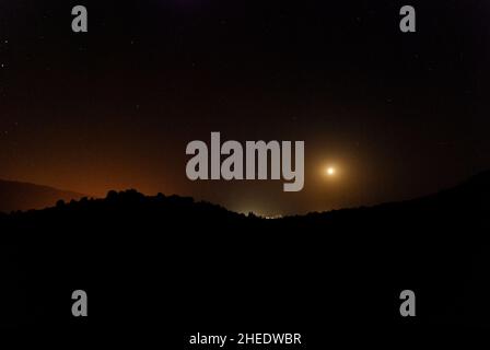 Moonlight illumina la silhouette di montagna orizzontale con cielo stellato 2 Foto Stock