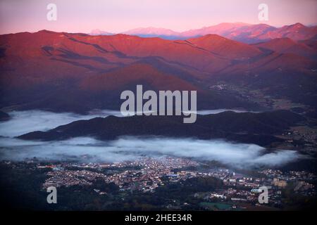 Mongolfiera che vola su Olot e montagne sullo sfondo in Garottxa Olot Girona provincia Catalogna, Spagna Foto Stock