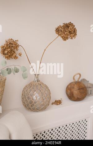 Disposizione minimalista di fiori secchi in vaso di vetro come decorazione domestica in stile scandinavo Foto Stock