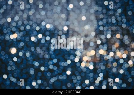 Sfondo astratto con luci blu e argento sfocate con effetto bokeh. Concetto di festa di Natale. Foto Stock