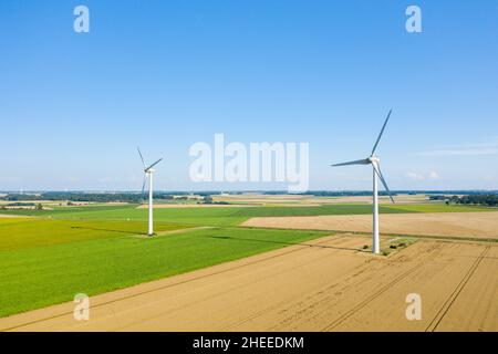 Questa foto di paesaggio è stata scattata in Europa, Francia, Normandia, in estate. Vediamo due turbine eoliche normanne al centro dei campi di lino e di grano, Foto Stock