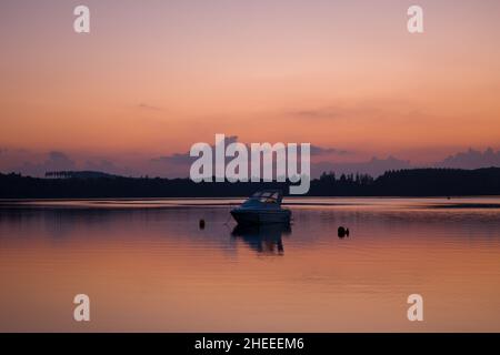 Questa foto di paesaggio è stata scattata in Europa, Francia, Borgogna, Nievre, Morvan, in estate. Vediamo una barca sul Lac des Settons al tramonto. Foto Stock