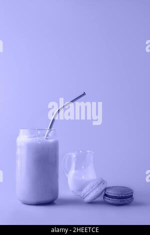 Bicchiere di caffè ghiacciato in alto vetro con paglia con panna e macaroon tondo di colore trendy dell'anno 2022 per il vostro design. Concetto di cibo. Spazio di copia. Primo piano. Foto Stock