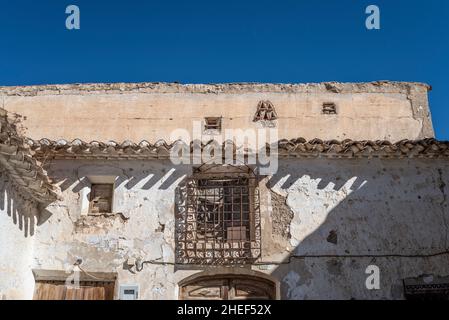 Casa colonica in decadenza a Oria, comune della provincia di Almería, nella comunità autonoma di Andalusia, Spagna. Rendering sfaldato. Ornare le barre della finestra Foto Stock