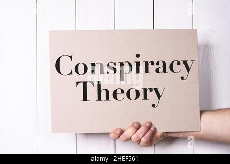 Un segno con le parole teoria della cospirazione tenuto nella mano Foto Stock