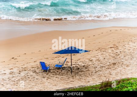 Ombrellone blu sulla spiaggia di Paciencia nel quartiere Rio Vermelho a Salvador, Bahia, Brasile. Foto Stock