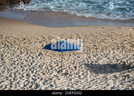 Ombrellone sulla spiaggia nel forte sole del giorno. Spiaggia di Paciencia a Salvador, Bahia, Brasile. Foto Stock