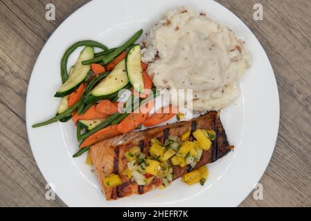 Vista dall'alto delle proteine ricche in questo abbondante filetto di salmone alla griglia servito con purè di patate e verdure miste. Foto Stock