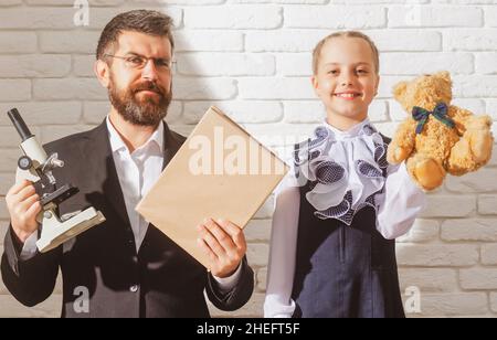 Piccola studentessa felice con un marchio eccellente. Carino piccolo bambino prescolare e insegnante in una classe. Ragazza carina della pupilla con faccia felice ed espressione Foto Stock