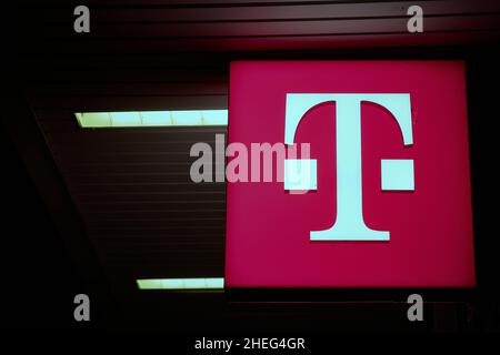 Pubblicità illuminata del fornitore di telefonia mobile Telekom nel centro della città di Berlino in serata Foto Stock