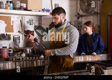 Uomo che prepara la saldatrice al lavoro Foto Stock