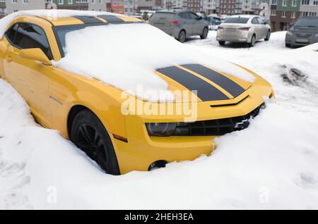 Vettura Camaro Chevrolet gialla sotto neve bianca. Omsk, Russia, 29.02.2020 Foto Stock