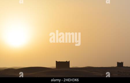 Due in mezzo ad un deserto case in piedi chiamati bivacchi. Esposizione al tramonto. Foto Stock