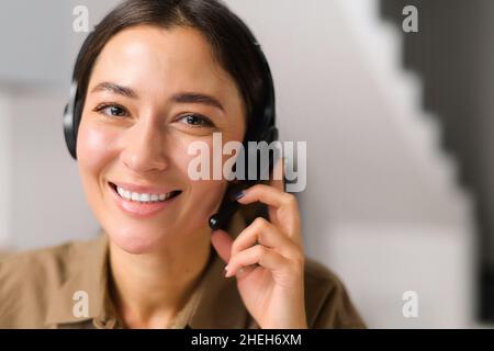 Headshot donna asiatica freelance indossare cuffia con microfono, donna amichevole in una cuffia che lavora a distanza nel reparto di assistenza clienti come operatore di call center, aiutando il cliente con la richiesta Foto Stock