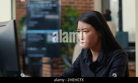 Ritratto dello sviluppatore di software infuriato si è concentrato sulla scrittura del codice dopo aver incontrato un errore di compilazione inaspettato seduto alla scrivania. Errore di sistema del programmatore durante la creazione dell'algoritmo. Foto Stock