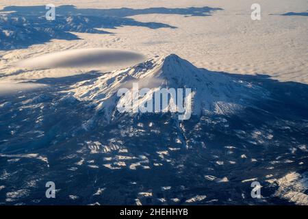 Vista aerea invernale sul Monte Shasta adornato da una nube lenticolare, California, USA Foto Stock