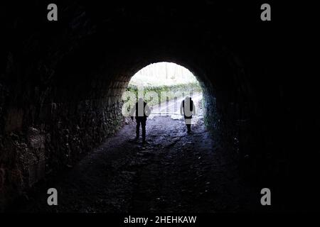 Due uomini che camminano in uno dei Victorian Servants Tunnels per Ingleborough Hall Estate a Clapham, Yorkshire Dales National Park, Inghilterra, Regno Unito. Foto Stock