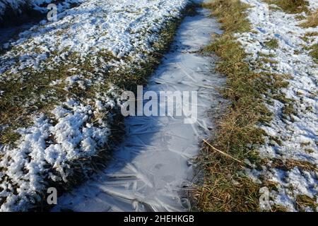 Ghiacciato Pattern on Frozen Puddle by Path to Ingleborough (1 of the Yorkshire 3 Peaks) da Clapham, Yorkshire Dales National Park, Inghilterra, Regno Unito. Foto Stock