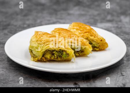 Pistacchio baklava (Sobiyet) su sfondo scuro. Prelibatezze della cucina tradizionale turca. Primo piano. Foto Stock