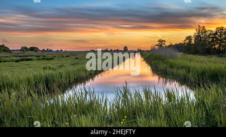 Tramonto sul canale nel paesaggio storico olandese a maggio vicino a Den ILP e Purmerend, Paesi Bassi Foto Stock