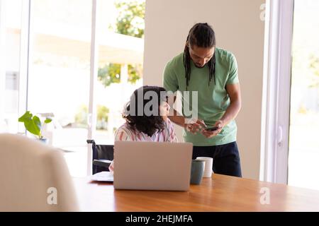 La donna afroamericana disabile e suo marito calcolano le finanze in casa Foto Stock