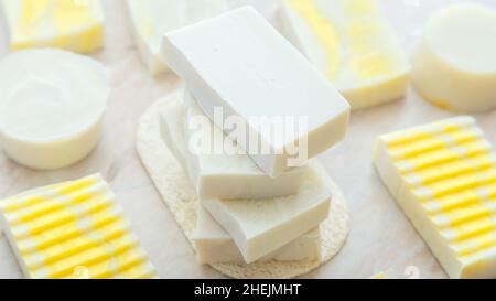 Saponi di oliva naturale modello bar. Molti saponi da bar fatti in casa bianchi. Sapone colorato giallo fatto a mano, prodotti da bagno spa per la cura della pelle del corpo. Igiene Foto Stock