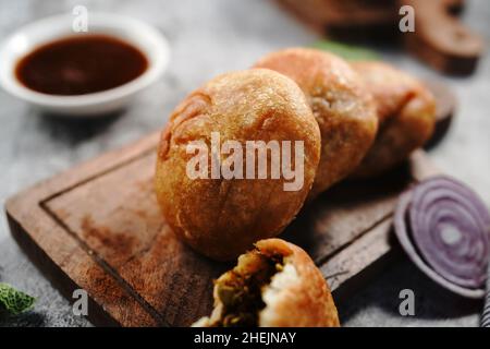 Kachori o Kachouri - popolare spuntino indiano fritto servito con chutney, fuoco selettivo Foto Stock