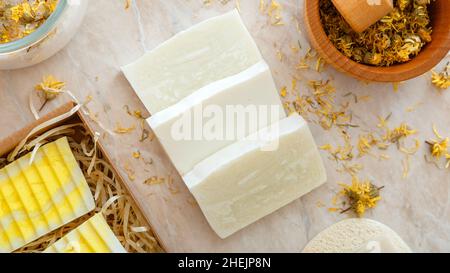 Saponette artigianali con erbe aromatiche fiori secchi. Prodotti da bagno naturali con fiori marigolenti secchi per la cura della pelle del corpo spa. Articoli da bagno per l'igiene Long web Foto Stock