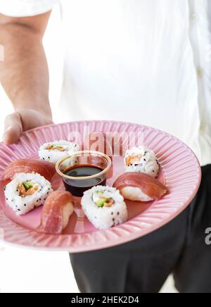 Piatto con pezzi assortiti di sushi. Foto Stock