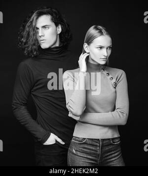 Ragazza concentrata in piedi accanto ad un ragazzo curly. Coppia attraente insieme. L'inizio della vita di una giovane coppia. La prima famiglia congiunta Foto Stock