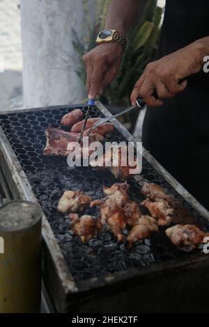 conde, bahia, brasil - 8 gennaio 2022: Persona che fa barbecue al carbone prasa nella città di Conde. Foto Stock