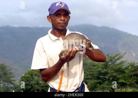 UN GESTORE CON UNA RAT GIGANTE ADDESTRATA (CRICETOMYS GAMBIANUS) PRESSO IL CENTRO DI FORMAZIONE APOPO, SOKOINE UNIVERSITY OF AGRICULTURE, MOROGORO, TANZANIA. AL CENTRO LA COMPAGNIA BELGA (APOPO), IL BAMBINO DI CERVELLO DI BART WEETJENS, STA ADDESTRANDO I RATTI PER INDIVIDUARE LE MINE TERRESTRI DA UTILIZZARE NELLE REGIONI DEVASTATE DALLA GUERRA. I RATTI SONO CONSIDERATI IDEALI PER IL LAVORO DI RILEVAMENTO DELLE MINIERE, ESSENDO PIÙ ECONOMICI DA ADDESTRARE RISPETTO AI CANI DA CECCHINO PIÙ CONVENZIONALI, OLTRE AD ESSERE PIÙ FACILI DA TRASPORTARE E MENO INCLINI A LEGARSI A GESTORI SPECIFICI. I RATTI SONO ANCHE RESISTENTI ALLE MALATTIE E RELATIVAMENTE POCO COSTOSI DA OSPITARE E NUTRIRE. Foto Stock