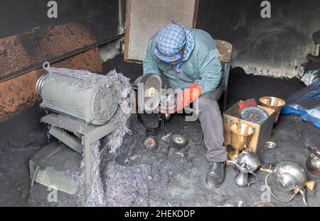 Ushaiqer, Arabia Saudita, 1st gennaio 2022: Uomo che lavora in un laboratorio polveroso, la produzione di caffè arabo pentole Foto Stock