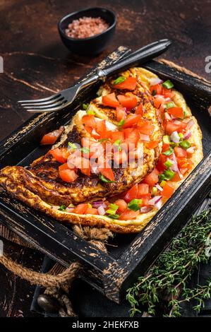 Frittata di uova strapazzate con pomodori, peperone rosso e cipolla. Sfondo scuro. Vista dall'alto Foto Stock