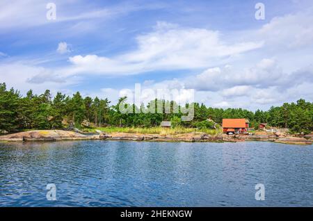 Paesaggio pittoresco con capanne a mare e cottage in legno in tipico rosso svedese ai margini dell'arcipelago di Småland vicino Oskarshamn, Svezia. Foto Stock