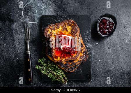 Toast francese al lampone con burro su tavola di marmo. Sfondo nero. Vista dall'alto Foto Stock