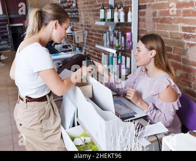 Amministratore che parla con il cliente dei servizi nel salone delle unghie Foto Stock