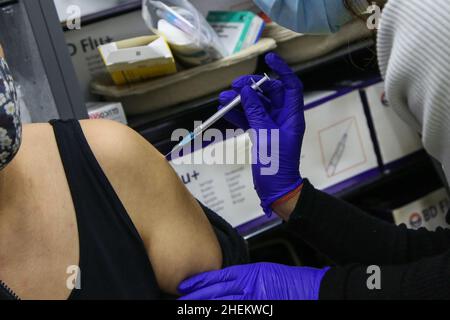 Londra, Regno Unito. 11th Jan 2022. Un operatore sanitario somministra il vaccino di richiamo moderna Covid-19 ad una donna in un sito di vaccinazione. (Credit Image: © Dinendra Haria/SOPA Images via ZUMA Press Wire) Foto Stock