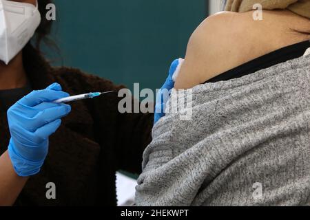 Londra, Regno Unito. 11th Jan 2022. Un operatore sanitario somministra il vaccino di richiamo moderna Covid-19 ad una donna in un sito di vaccinazione. (Credit Image: © Dinendra Haria/SOPA Images via ZUMA Press Wire) Foto Stock