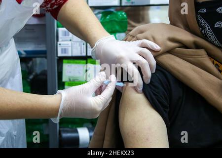 Londra, Regno Unito. 11th Jan 2022. Un operatore sanitario somministra il vaccino di richiamo moderna Covid-19 ad una donna in un sito di vaccinazione. (Credit Image: © Dinendra Haria/SOPA Images via ZUMA Press Wire) Foto Stock