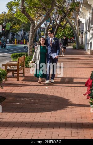 Una coppia appena sposata che cammina lungo state Street a Santa Barbara, California. Foto Stock