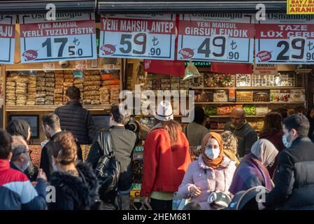 Istanbul, Turchia. Gennaio 5th 2022 gli amanti dello shopping fuori dal Bazaar Egiziano, un mercato di cibo occupato popolare tra la gente del posto e i turisti, con i segni che mostrano il prezzo Foto Stock