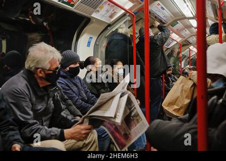 Londra (UK), 11.01.2022: Pendolari sulla metropolitana di Londra che viaggiano in un carro completo poco prima dell'inizio dell'ora di punta della sera. Foto Stock