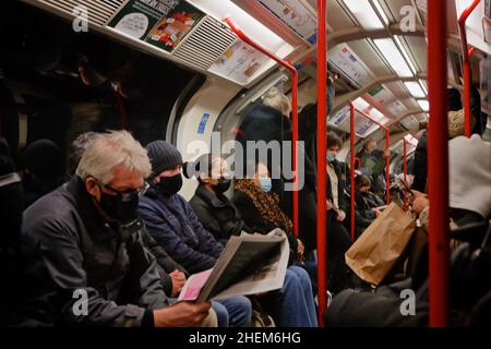 Londra (UK), 11.01.2022: Pendolari sulla metropolitana di Londra che viaggiano in un carro completo poco prima dell'inizio dell'ora di punta della sera. Foto Stock