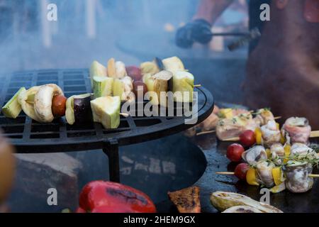 Cottura di verdure sul processo di fuoco. Grigliare cibo salute. Fumo sullo sfondo. Foto Stock