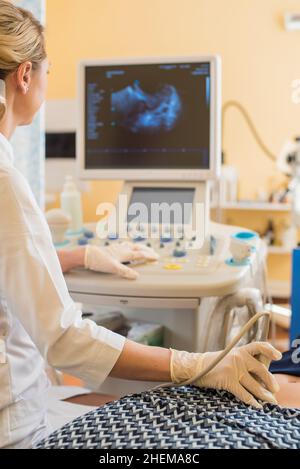 bel ginecologo esamina i dispositivi medici. Il paziente si trova sul lettino Foto Stock